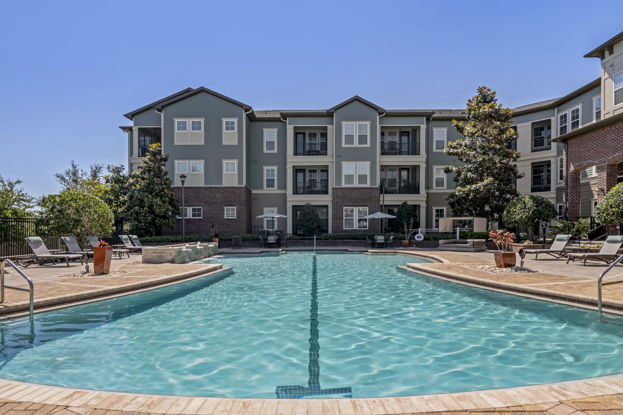 Pool with deck seating, cabanas, and covered tables