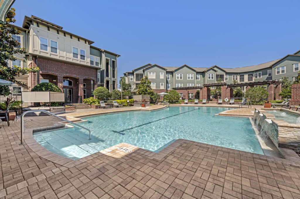 pool with deck seating, cabanas, and covered grilling stations