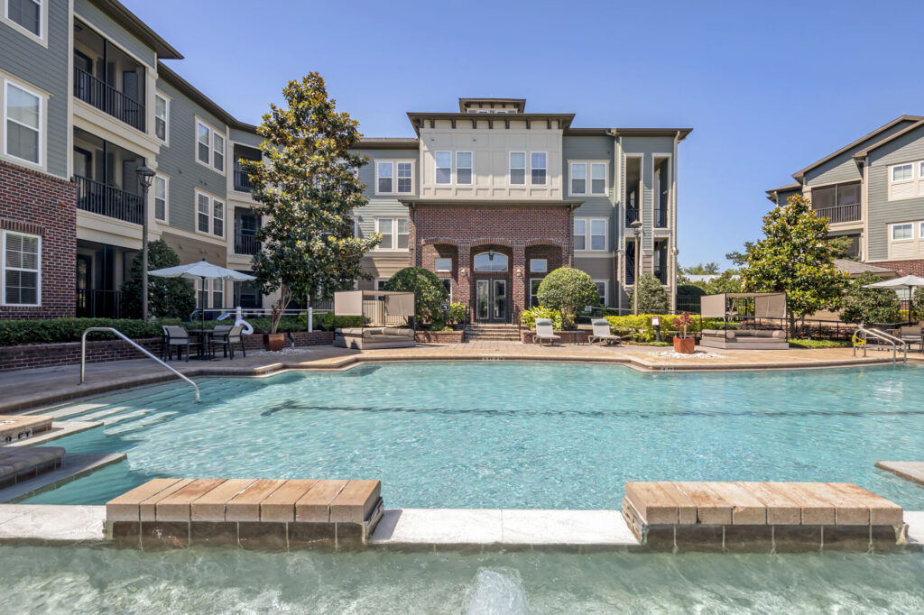 Pool with deck seating, covered tables, and cabanas