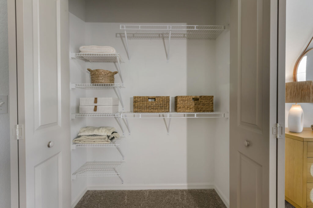 Large closet with built in shelves and carpet flooring
